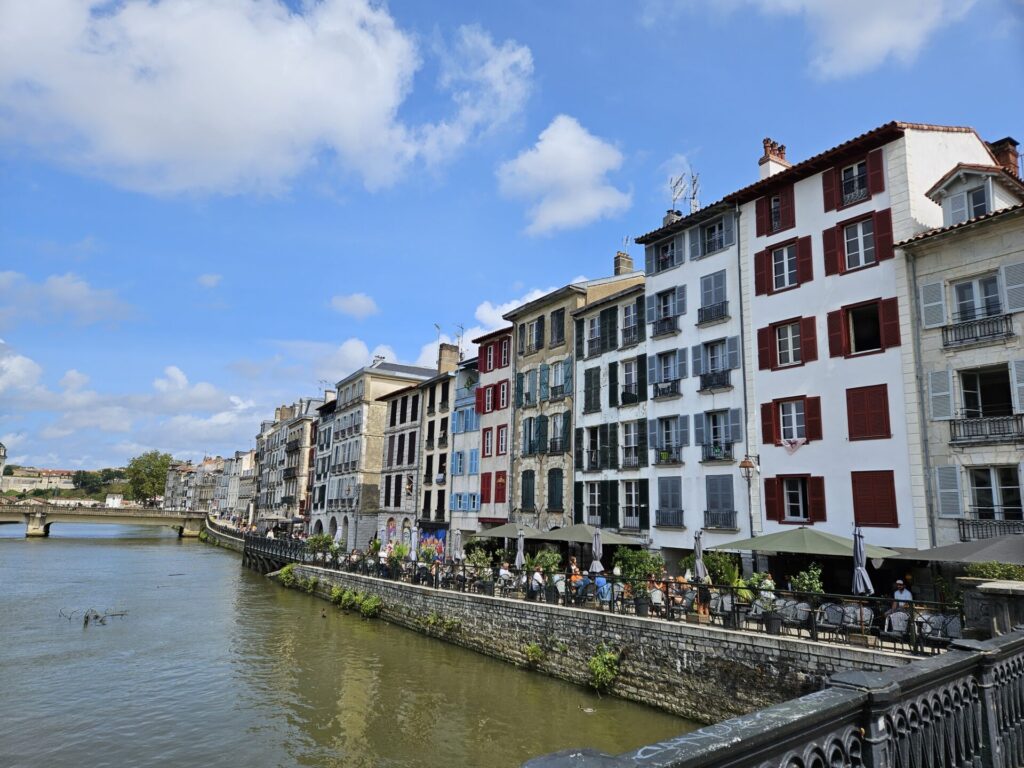 Cafes along the Nive River in Bayonne overlooked by quaint apartments