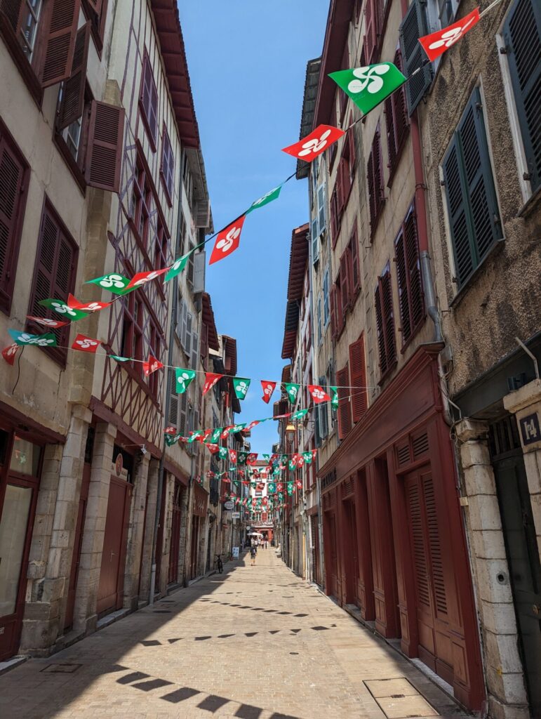 Narrow walkways with Basque flags cris-crossing the street, proud images of Bayonne.